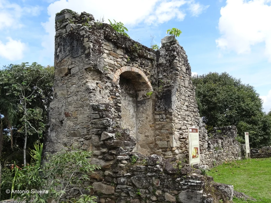 Restos da estrutura da Igreja do Abarebebê, com paredes de pedra e vegetação ao redor.