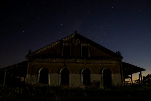 Prédio abandonado capturado durante a noite, ilustrando o silêncio e a história presentes nas ruínas