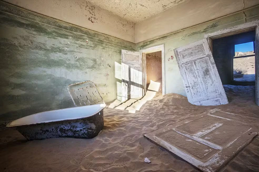 Interior de uma casa em Kolmanskop, Namíbia, parcialmente preenchida por areia do deserto