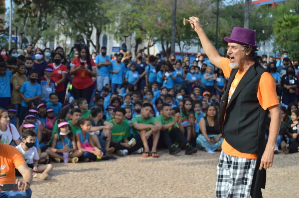 Grupo de pessoas reunidas em círculo, participando de uma sessão de contação de histórias em uma comunidade brasileira.