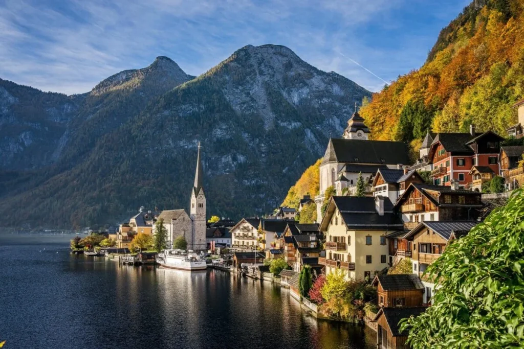 Vista contemplativa de Hallstatt, Áustria, refletida no lago com montanhas ao fundo.